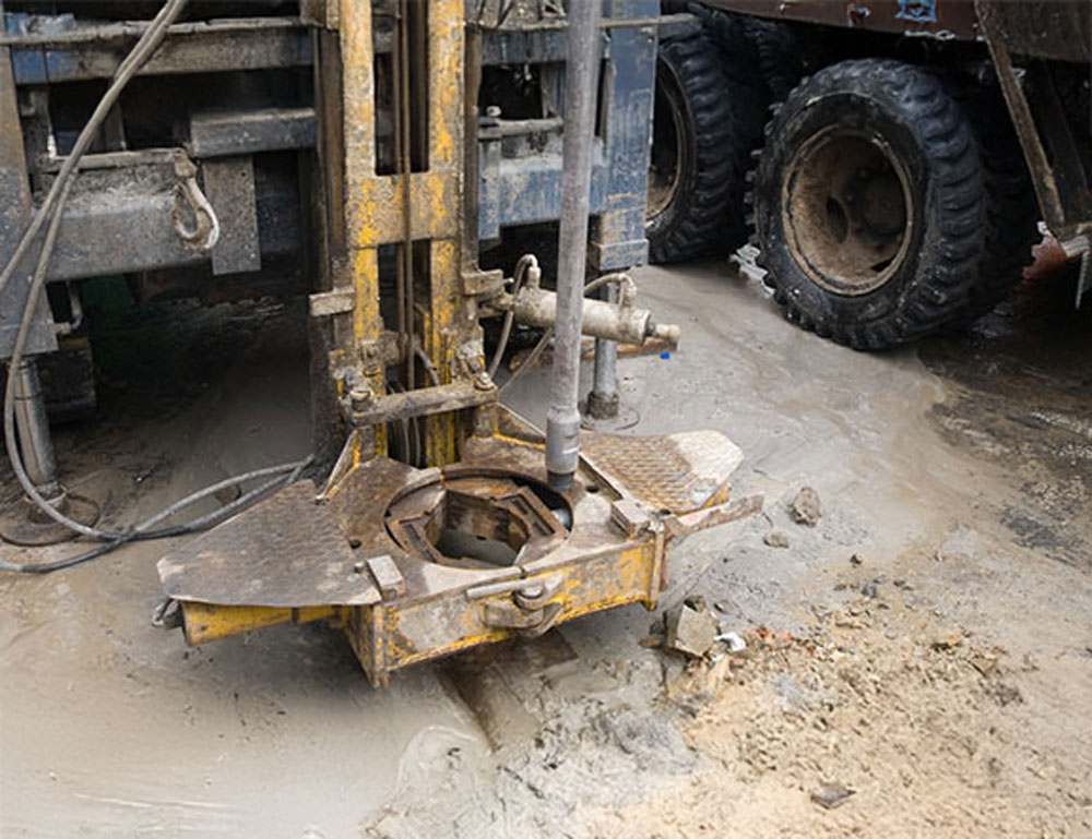 Well drilling rig boring through concrete during a job in Portage County, OH