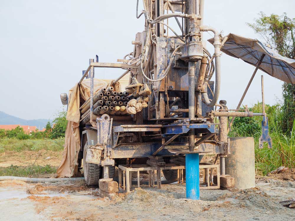 Drilling rig boring a new water well into muddy ground in Portage County, OH